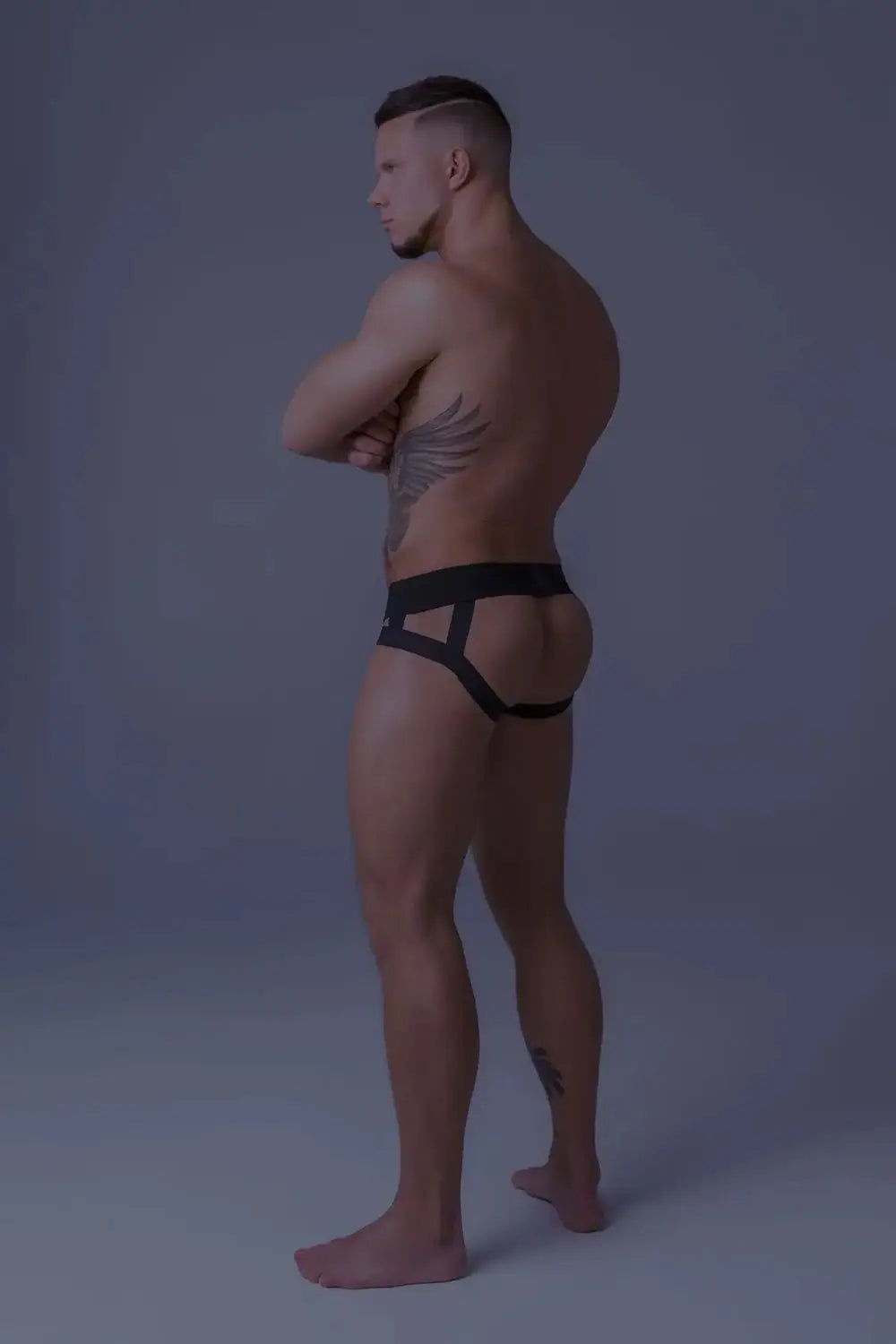 Maskulo Youngero orange-neon fetish jockstrap with black mesh codpiece and UV glowing accents for men